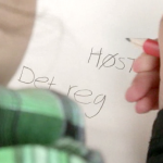En elev skriver på et ark. Det står Høst. Det reg