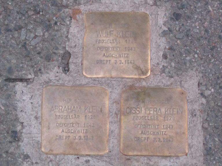 Bilde av tre metallplater med navn på tre medlemmer av familien Klein som ble deportert til Auschwitz i 1943