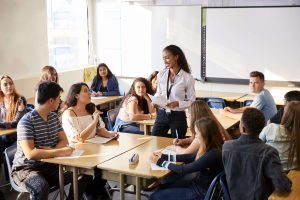 Kvinnelig lærer med elever/deltakere i et klasserom.