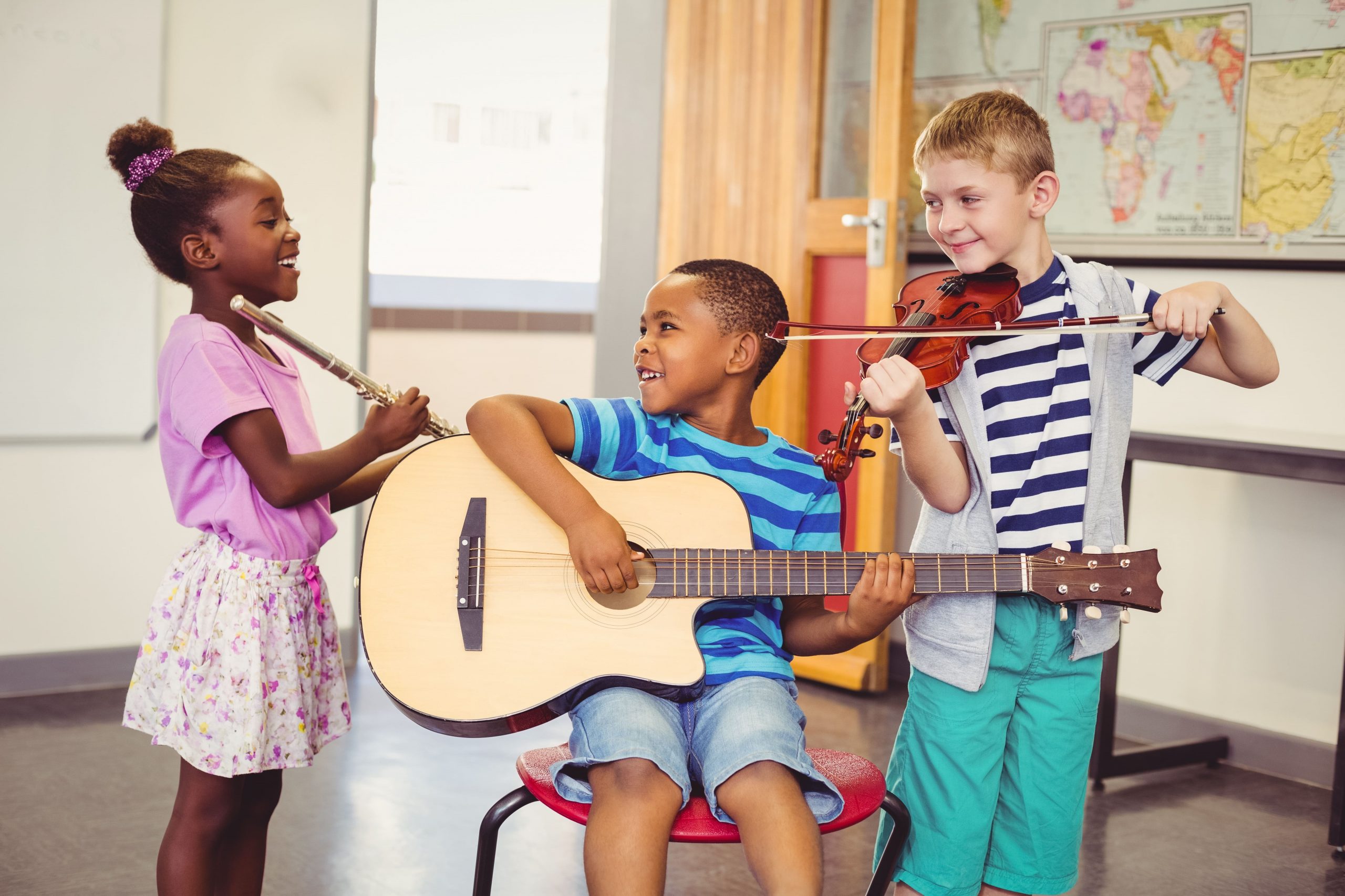 tre barn synger og spiller gitar.