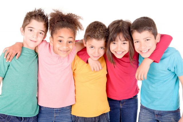 Fem barn med ulik hudfarge står på rekke og holder rundt hverandre.