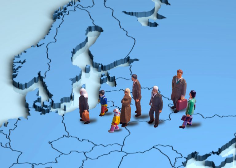 Foto av en gruppe figurer, formet som mennesker, som forflytter seg på et kart. Kartet er over Europa og gruppa er på vei mot Norge.