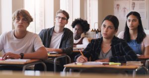 Education, college and students sitting in a classroom for learning, studying or future development. School, university and scholarship with a group of pupils in class lecture together to learn.